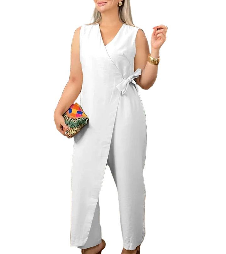 Woman wearing a white sleeveless jumpsuit holding a colorful clutch on a white background
